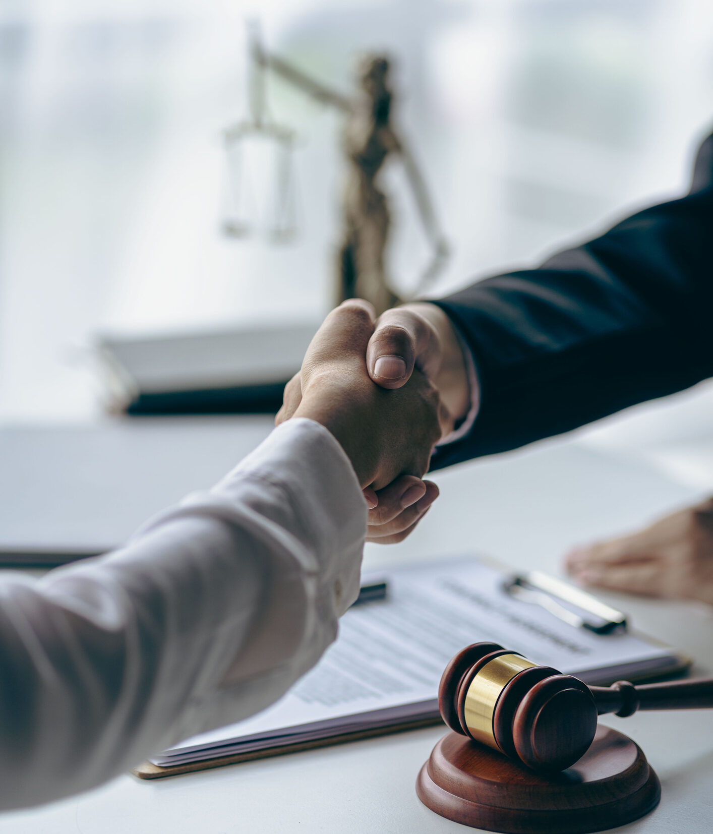 Lawyer shaking hands with client after agreement Gavel Justice hammer on wooden table with judge and client shaking hands after advice in courtroom, notary service concept